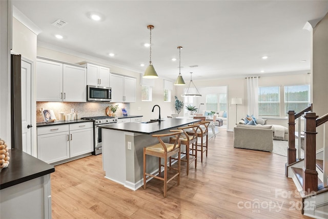13709 Roderick Dr Unit 193, Huntersville, NC 28078 - kitchen with a kitchen breakfast bar, dark countertops, a kitchen island with sink, stainless steel appliances, and a sink
