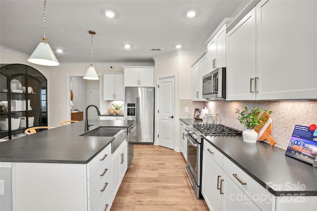 13709 Roderick Dr Unit 193, Huntersville, NC 28078 - kitchen with high quality appliances, an island with sink, dark countertops, light wood-style floors, and a sink
