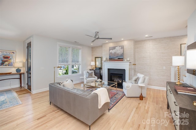 107 Iris Meadow Dr, Mooresville, NC 28115 - living room featuring light wood finished floors, baseboards, a glass covered fireplace, and a ceiling fan