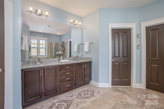 107 Iris Meadow Dr, Mooresville, NC 28115 - bathroom with a stall shower, double vanity, baseboards, and a sink