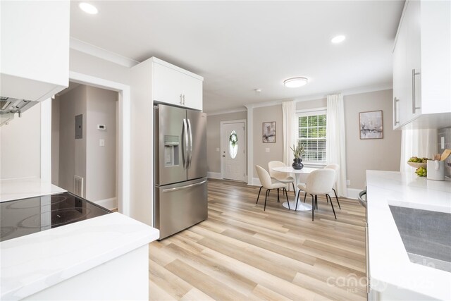 kitchen with white cabinets, light countertops, ornamental molding, and stainless steel fridge with ice dispenser