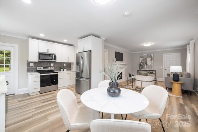 dining space with crown molding, light wood-style flooring, recessed lighting, and baseboards