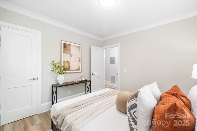 bedroom featuring crown molding, visible vents, baseboards, and light wood-style floors