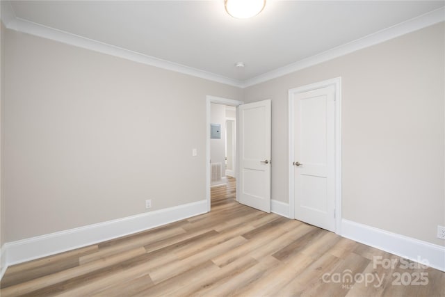 unfurnished bedroom featuring baseboards, visible vents, ornamental molding, and light wood finished floors