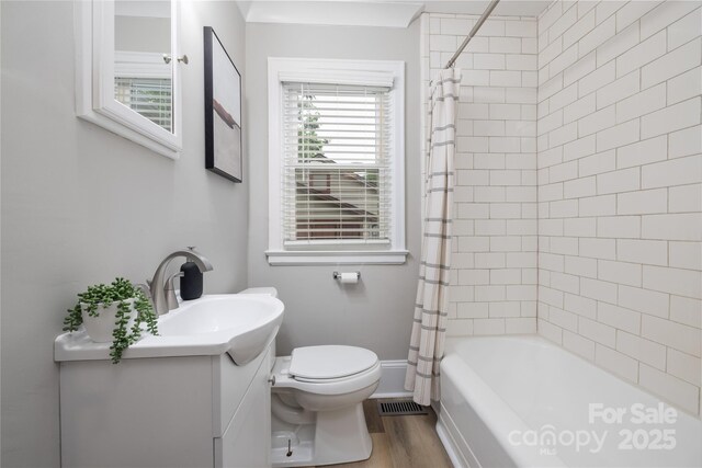 bathroom with vanity, shower / bath combo with shower curtain, toilet, visible vents, and wood finished floors