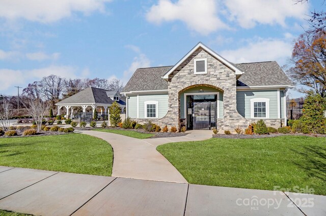 8038 Downy Oak Ln, Charlotte, NC 28269 - view of front of house featuring stone siding, a shingled roof, a gazebo, and a front yard