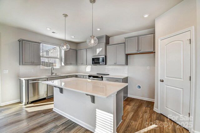 8042 Downy Oak Ln, Charlotte, NC 28269 - kitchen with a sink, dark wood-style floors, gray cabinetry, stainless steel appliances, and visible vents