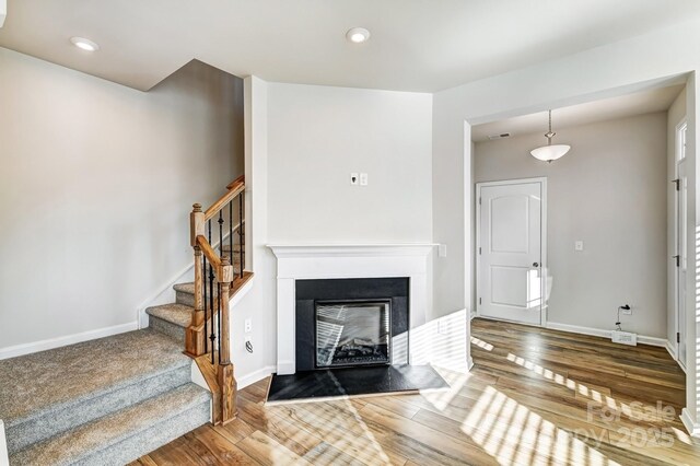 8042 Downy Oak Ln, Charlotte, NC 28269 - living room with baseboards, stairs, a fireplace with flush hearth, and wood finished floors