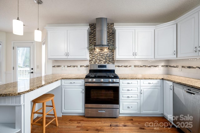 51 Sugar Hill Dr, Weaverville, NC 28787 - kitchen with white cabinets, light wood-type flooring, backsplash, wall chimney range hood, and appliances with stainless steel finishes
