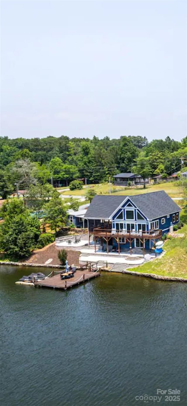 exterior space with a water view and a forest view