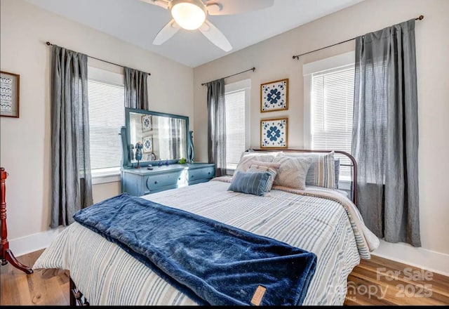 bedroom with wood finished floors, baseboards, and a ceiling fan