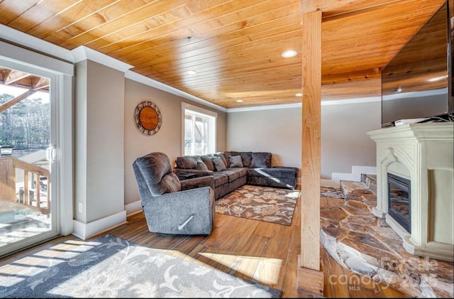 living room with wood ceiling, wood finished floors, and a healthy amount of sunlight