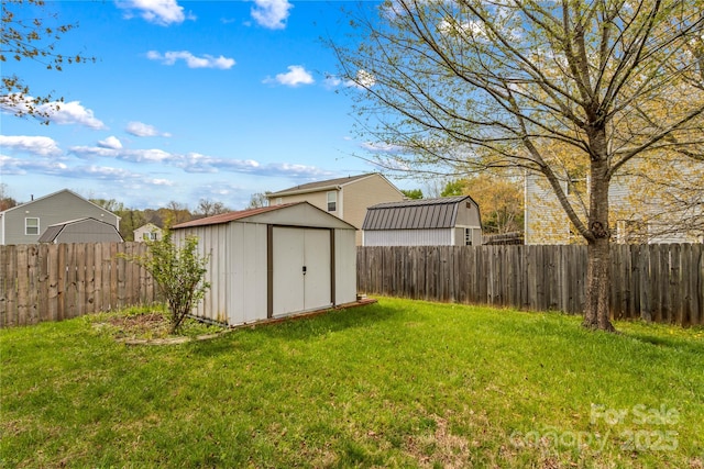 view of yard with a fenced backyard, an outdoor structure, and a storage unit