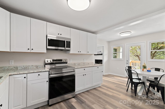 507 N Fork Rd, Black Mountain, NC 28711 - kitchen with appliances with stainless steel finishes, light wood-style flooring, healthy amount of natural light, and white cabinetry