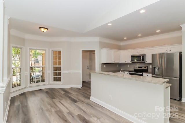 kitchen with light stone counters, recessed lighting, light wood-style flooring, white cabinets, and stainless steel appliances