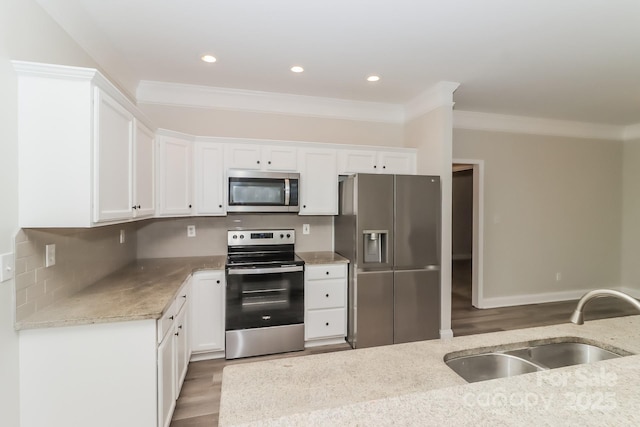 kitchen with appliances with stainless steel finishes, a sink, and white cabinets