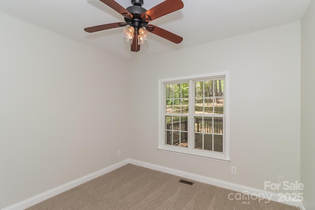 empty room with carpet, visible vents, baseboards, and ceiling fan