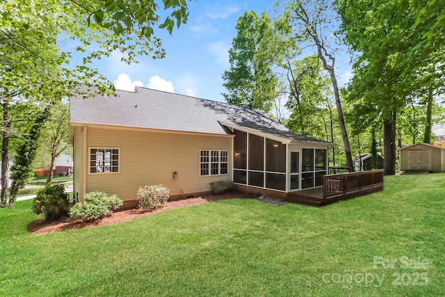 back of property featuring a sunroom, a shed, a yard, an outbuilding, and roof with shingles
