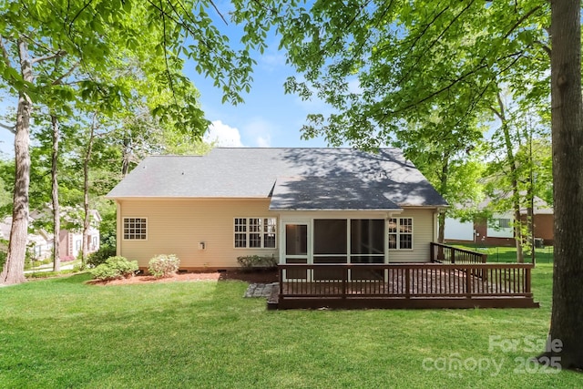 rear view of house featuring a yard and a sunroom