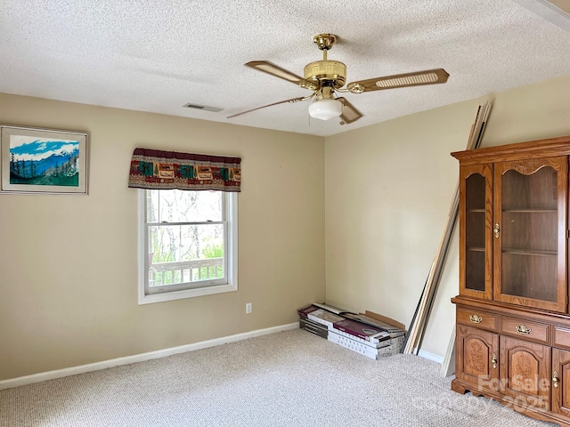 spare room with visible vents, a textured ceiling, a ceiling fan, and carpet floors