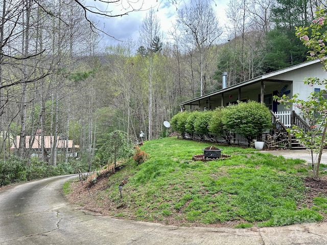 view of yard featuring a forest view and a fire pit