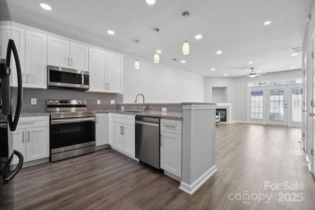 4211 Center Place Dr, Harrisburg, NC 28075 - kitchen featuring stainless steel appliances, backsplash, a sink, ceiling fan, and a peninsula
