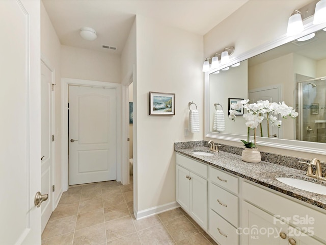 bathroom featuring a shower stall, tile patterned floors, a sink, double vanity, and visible vents