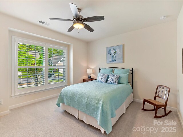 carpeted bedroom featuring baseboards, visible vents, and ceiling fan