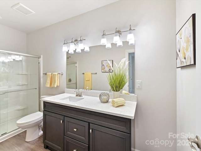 full bath featuring toilet, wood finished floors, visible vents, and a stall shower