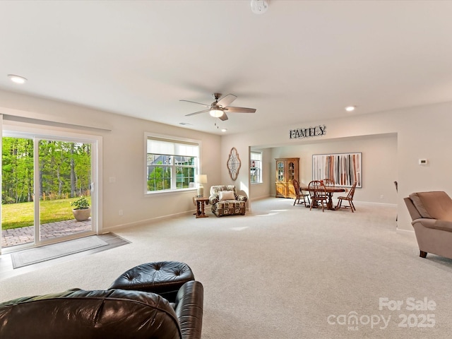 carpeted living area with a ceiling fan, baseboards, and recessed lighting