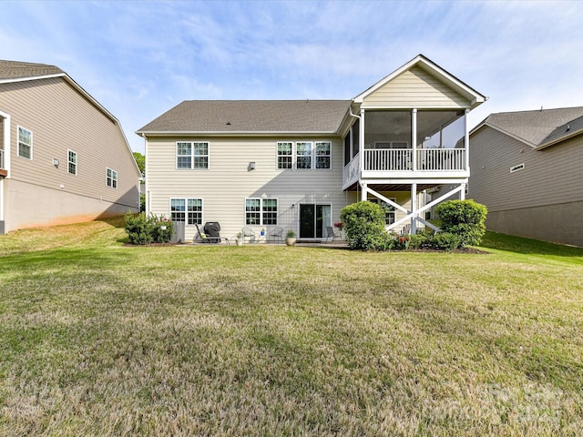 back of house featuring a yard, a patio area, and a sunroom