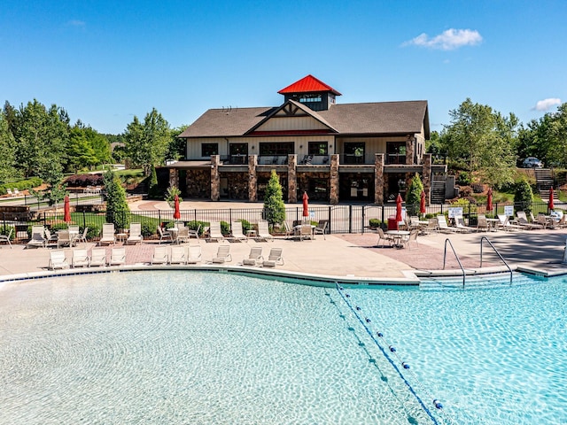 pool featuring fence and a patio