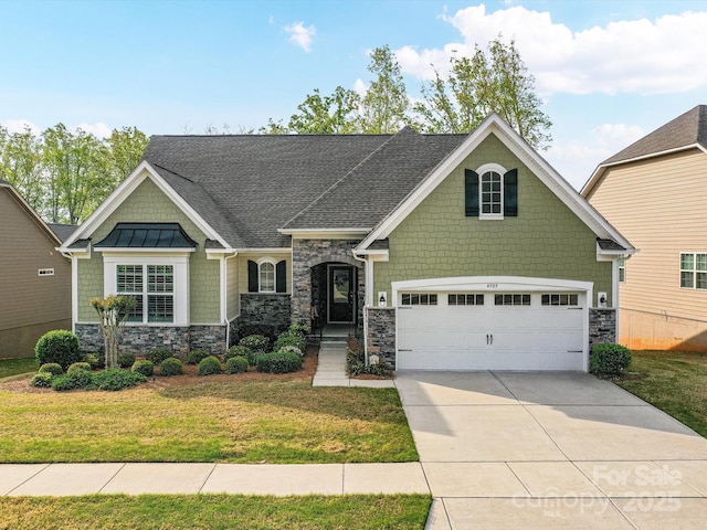 craftsman-style house with an attached garage, stone siding, a front yard, and concrete driveway