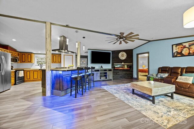 living room with light wood-style flooring, ceiling fan, and vaulted ceiling