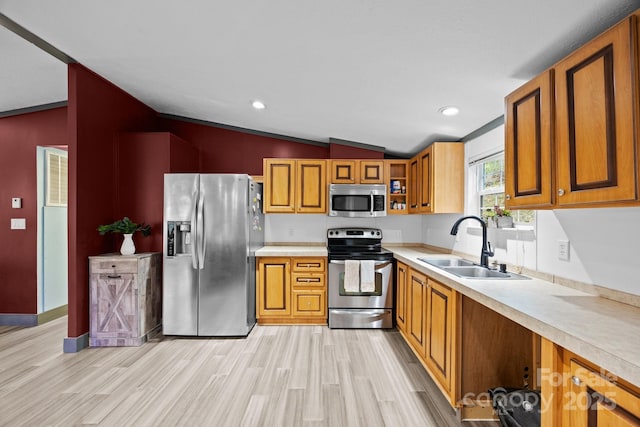 kitchen featuring light countertops, light wood-type flooring, appliances with stainless steel finishes, brown cabinetry, and lofted ceiling