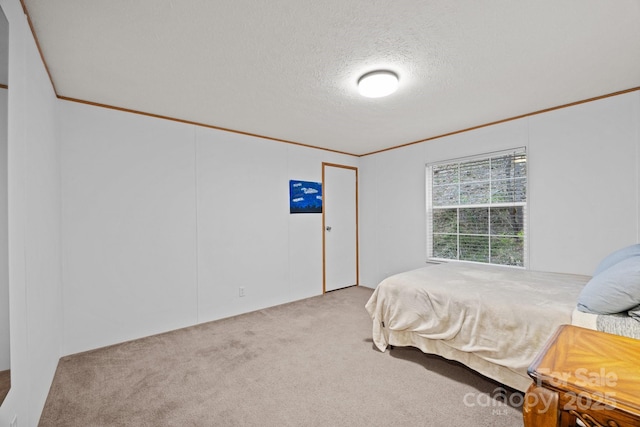 bedroom with crown molding, carpet, and a textured ceiling