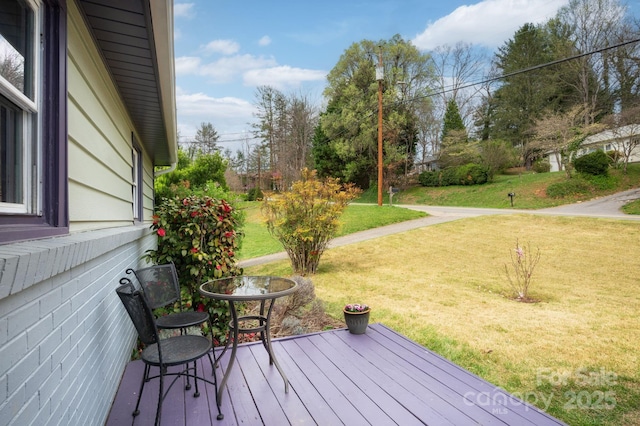 wooden terrace with a lawn