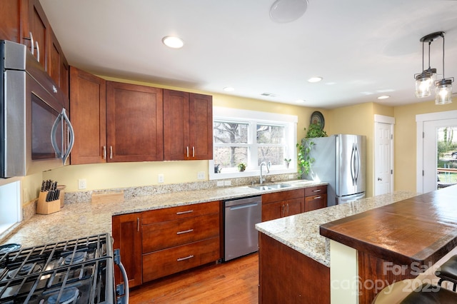 kitchen with light wood-style flooring, a sink, recessed lighting, and appliances with stainless steel finishes