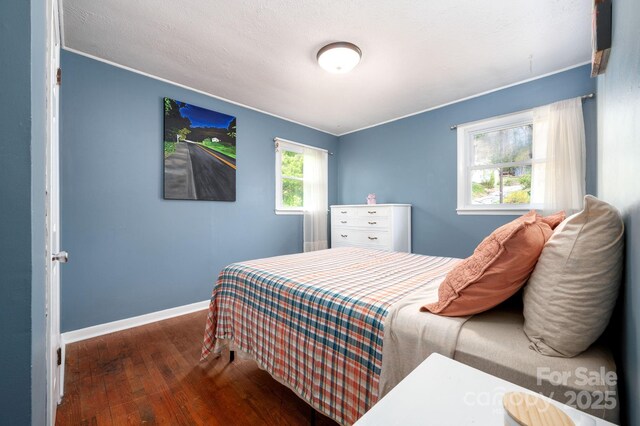 bedroom with hardwood / wood-style floors, baseboards, and ornamental molding