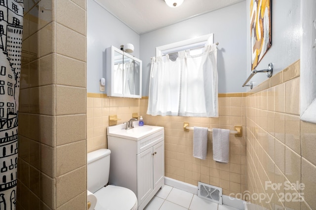 full bath with tile patterned floors, vanity, tile walls, toilet, and visible vents