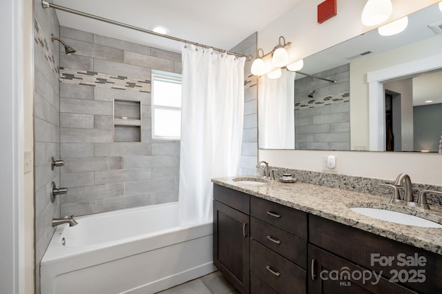 bathroom with shower / bath combination with curtain, visible vents, a sink, and double vanity