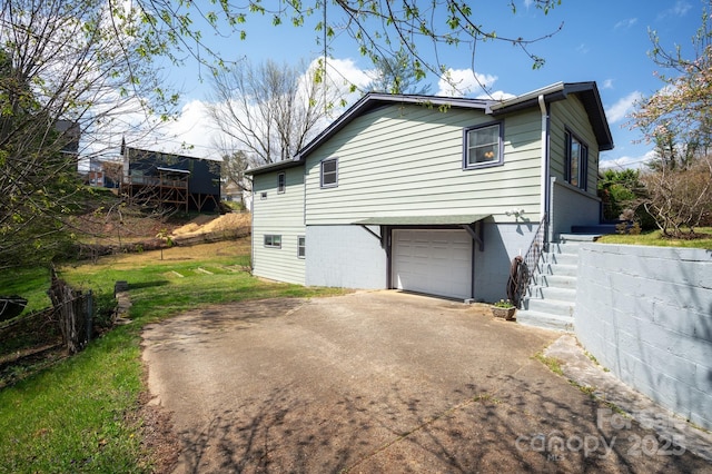 view of property exterior with an attached garage, concrete driveway, and fence