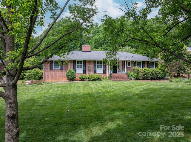 ranch-style house with a front lawn, a chimney, and brick siding