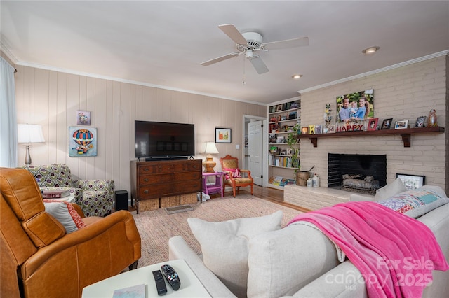 living room with crown molding, a fireplace, wood finished floors, a ceiling fan, and built in shelves