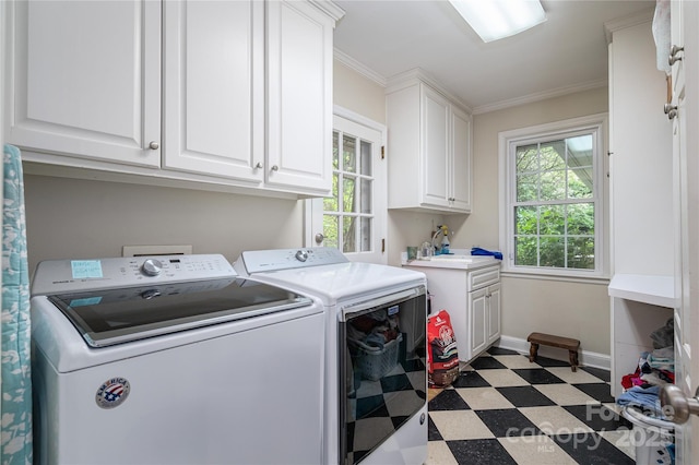 clothes washing area featuring light floors, cabinet space, ornamental molding, washing machine and dryer, and baseboards