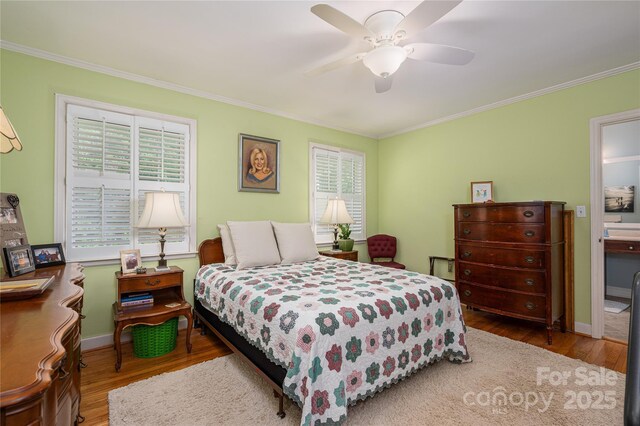 bedroom featuring wood finished floors, ceiling fan, crown molding, and baseboards