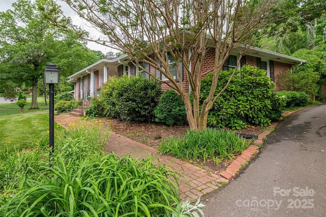 view of home's exterior with a yard and brick siding