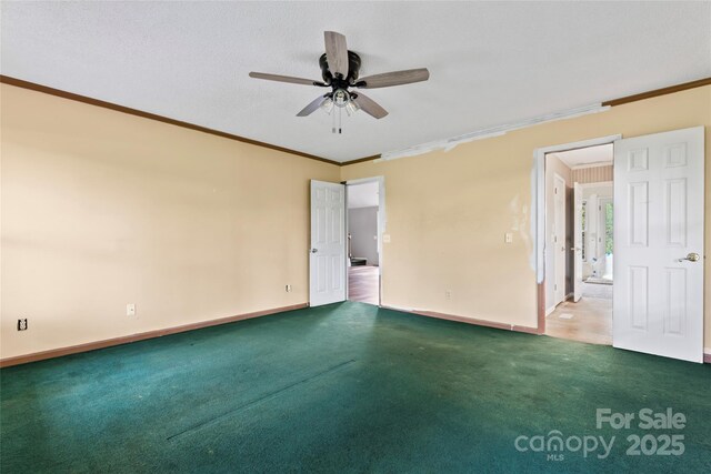 carpeted empty room featuring baseboards, ornamental molding, and ceiling fan