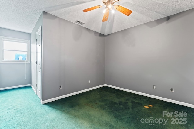 carpeted empty room featuring baseboards, visible vents, a textured ceiling, and a ceiling fan
