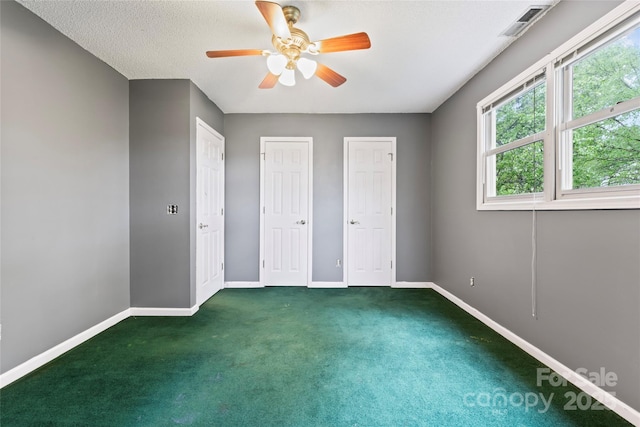 unfurnished bedroom with visible vents, baseboards, multiple closets, and carpet floors